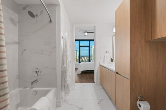 a bathroom with a shower and a sink and a bed