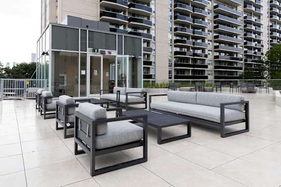 A set of outdoor furniture is arranged on a tiled patio.