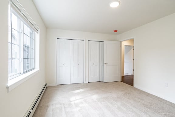 an empty room with white walls and white doors and a window