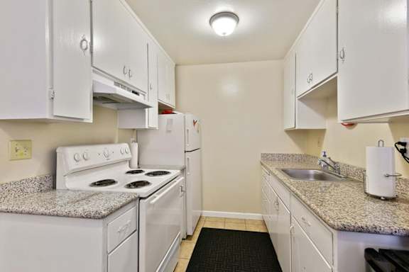 A kitchen with white appliances and cabinets.