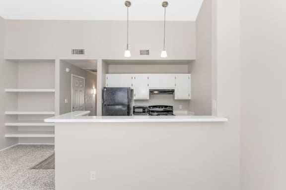 A modern kitchen with a white countertop and stainless steel appliances.