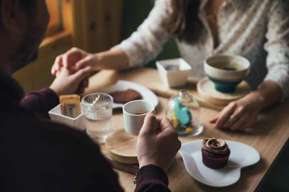 people sitting around a table drinking coffee and holding hands at Edgemont Apartments, PRG Real Estate, Greenville, 29615