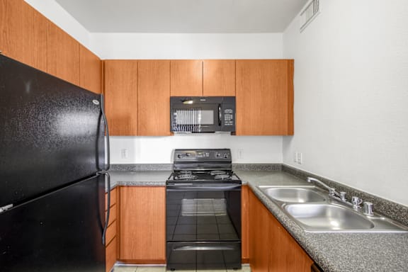 Kitchen with black appliances at San Fernando Apartments, Mesa, AZ