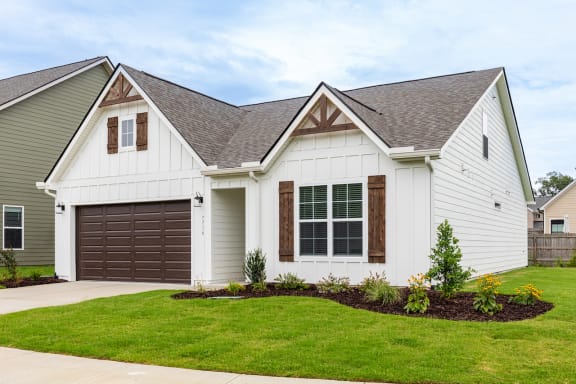 a white house with a lawn and a driveway