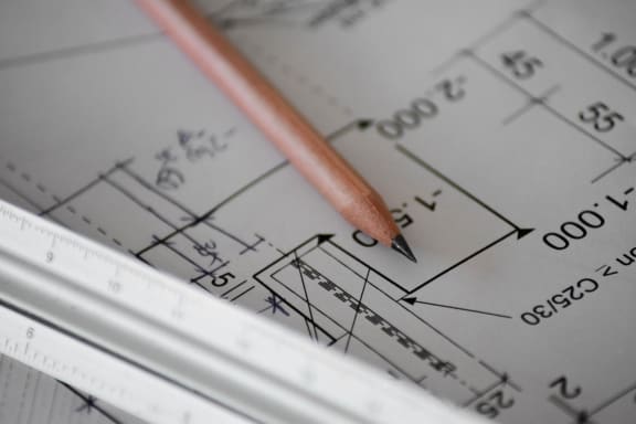 a pencil sitting on top of a drawing of a house
