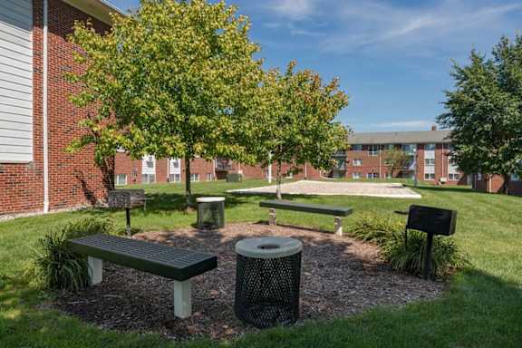 a park with benches and trees in front of a building at Village Club of Royal Oak, Royal Oak, MI 48067