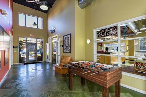 a game room with a foosball table and a chair at Village Club of Royal Oak, Royal Oak