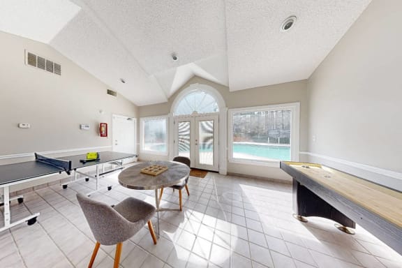 a game room with a table and chairs and a pool