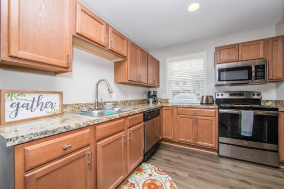 Kitchen with stainless steel appliances at Villages at City Center apartments in Newport News VA