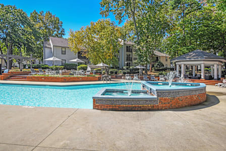 A pool with a fountain in the middle of it.