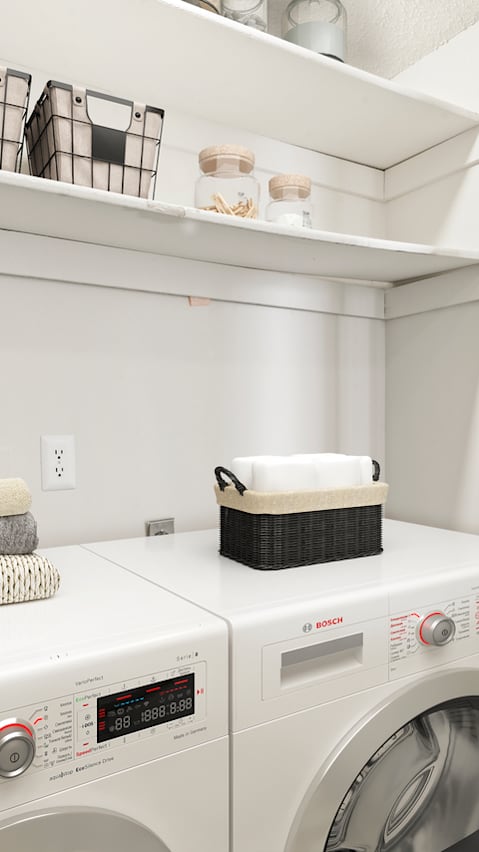 A modern kitchen with white cabinets and a black fridge.