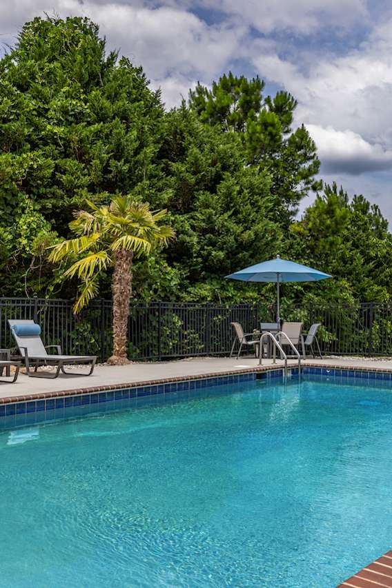 a swimming pool with chairs and umbrellas at the resort