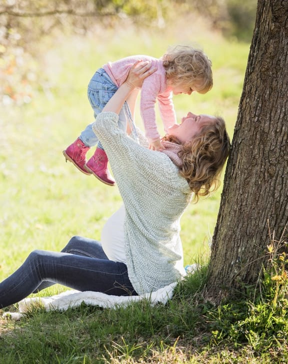 a mother playing with her child in a park