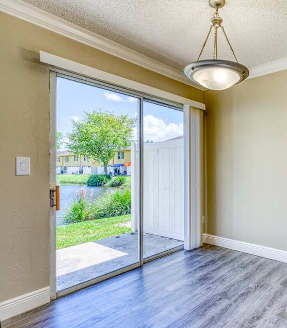an empty living room with hard wood floors and a window