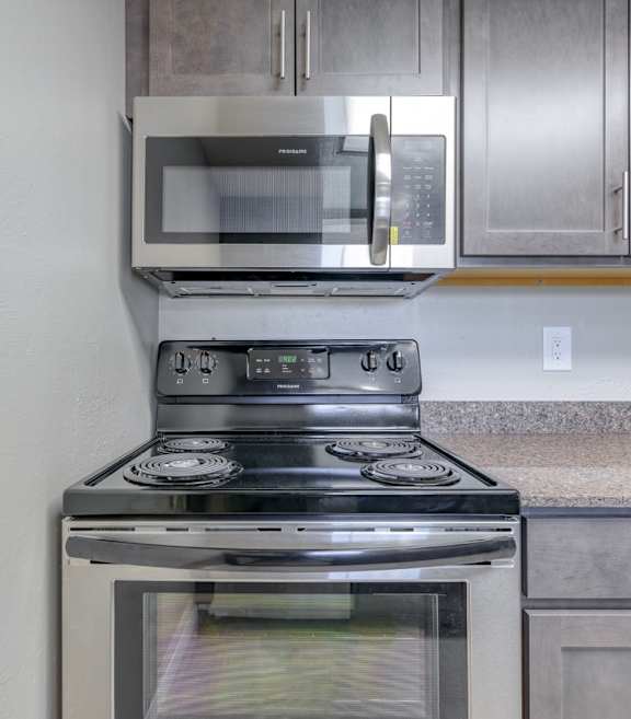 an oven and microwave in a kitchen with granite counter tops