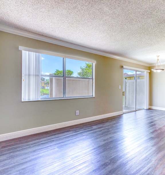 an empty living room with hard wood floors and a window
