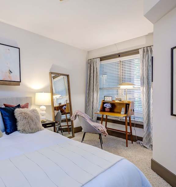 A bedroom with a large bed and a painting on the wall.