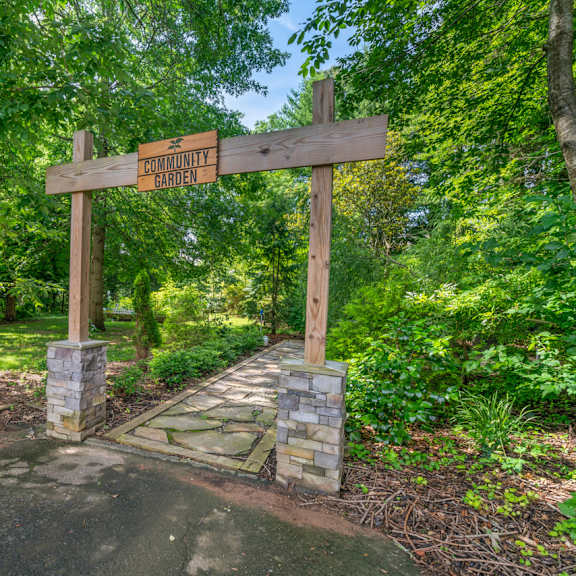 A wooden signpost with the words "ENTICULOUS GARDEN" on it.