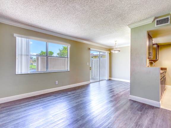 an empty living room with hard wood floors and a window