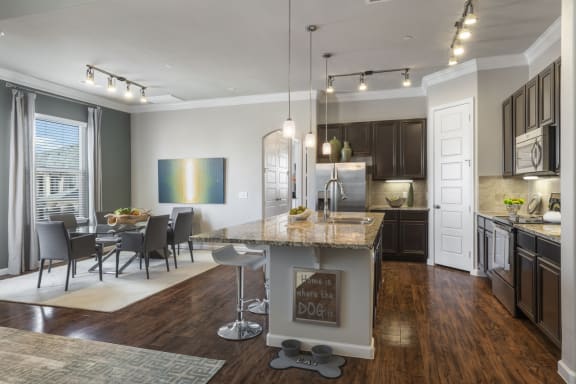 kitchen with white cabinetry, double-basin sink, and breakfast bar
