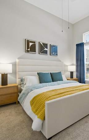 A bed with a white comforter and a brown pillow is in the image.