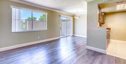 an empty living room with hard wood floors and a window