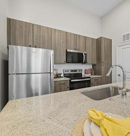 A kitchen with a granite countertop and stainless steel appliances.
