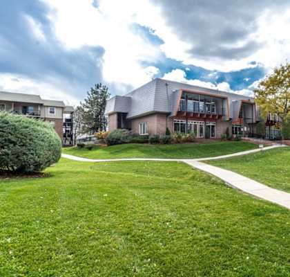 A large house with a green lawn in front.