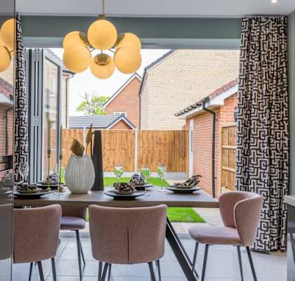 a dining room with a table and chairs in front of a sliding glass door