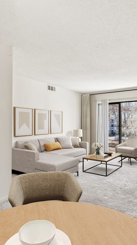 A modern living room with a grey sofa, a coffee table, and a painting on the wall.
