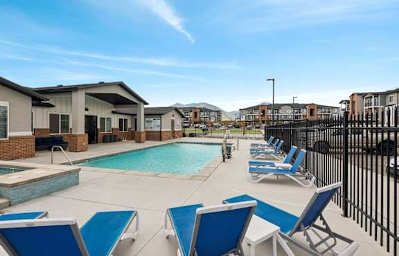 A pool surrounded by blue lounge chairs.