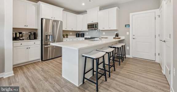 A kitchen with white cabinets and a large island.