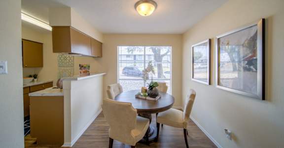 a dining room and kitchen with a large window at Villas del Tesoro Apartments, Dallas, TX, 75228
