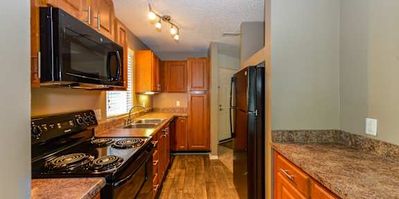 a kitchen with black appliances and granite counter tops