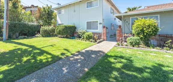 a blue house with a lawn and a sidewalk
