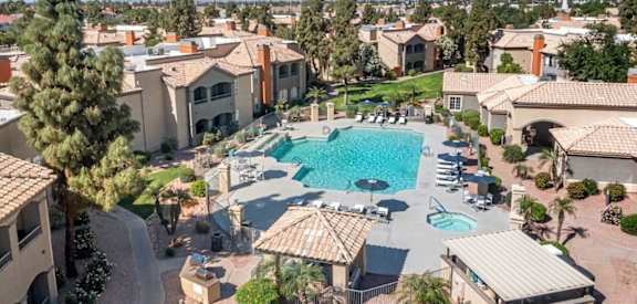 A large, luxurious pool surrounded by a gated community.