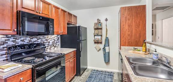 A kitchen with wooden cabinets and black appliances.