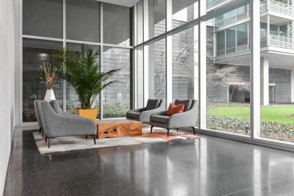 a living room with chairs and a table in front of a window