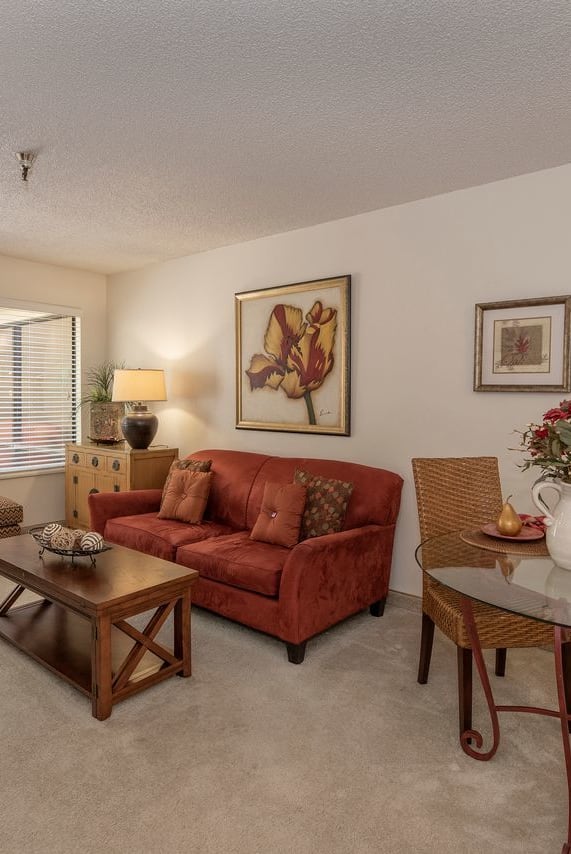 a living room with white couches and a coffee table at Campus Commons Senior Living, Sacramento