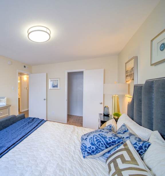 a bedroom with a large bed and a mirror at Villas del Tesoro Apartments, Dallas, TX, 75228