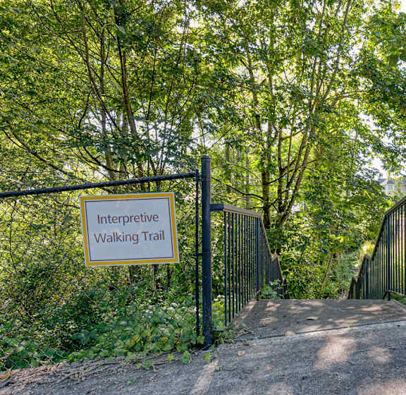 A sign that says Interpretive Walking Trail is on a gate.