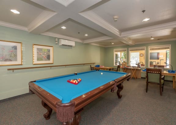 a large dining room with tables and chairs and windows at Campus Commons Senior Living, Sacramento California