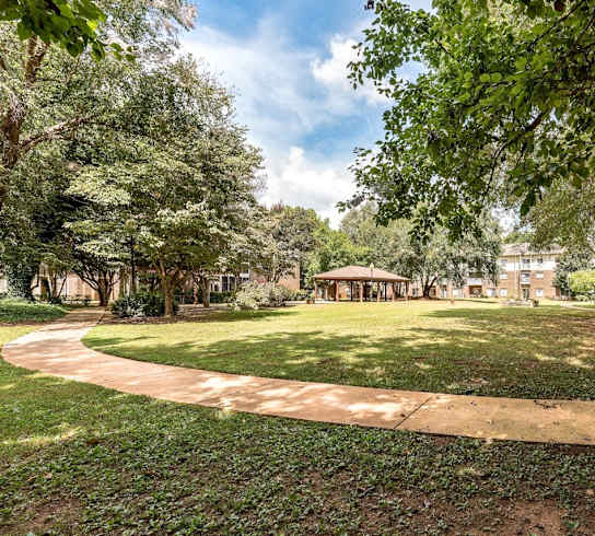 a park with trees and a path leading to a gazebo