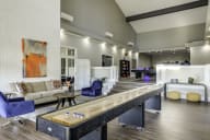Community clubhouse with a shuffleboard table and lounge seating