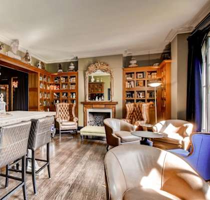 a living room filled with furniture and a bar and a fireplace at York House, Missouri, 63108