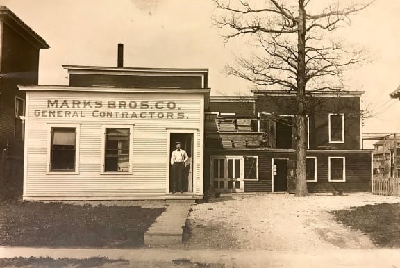a black and white photo of a building with a person standing in the door