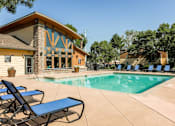 Thumbnail 2 of 26 - Apartments for Rent in Aurora, Colorado - Copper Flats - Swimming Pool with Spacious Sundeck, Lounge Chairs, Tables, and Manicured Greenery.
