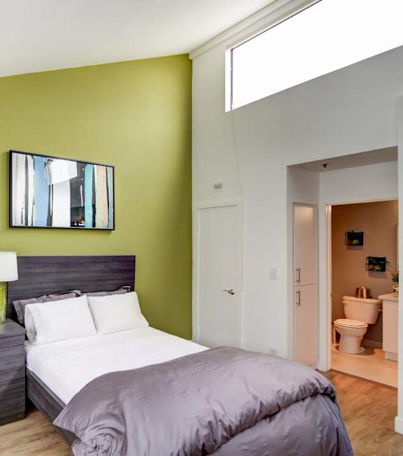 a living room with a spiral staircase and a couch and a table at El Greco Lofts, Los Angeles