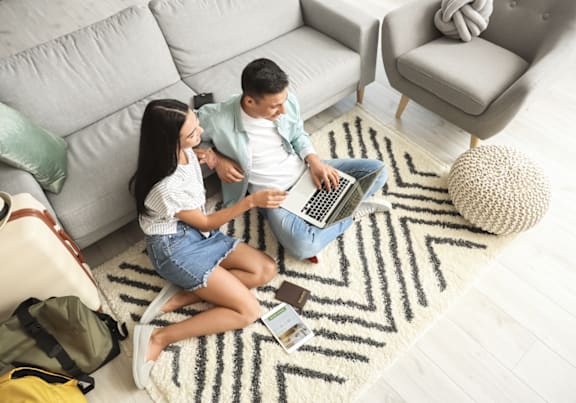a living room with white couches and rattan chairs
