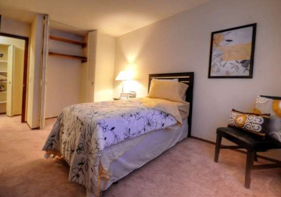 a bedroom with a bed and a chair and a closet